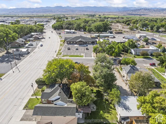 Aerial perspective showcasing the property's location within a developed area with extensive green spaces and distant mountains