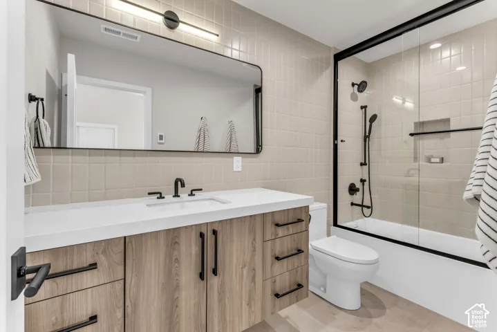 Wood-finish vanity with a white countertop and matte black fixtures