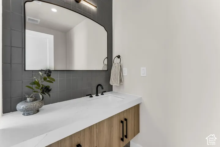 Floating vanity with wood-finish cabinetry, white countertop, and integrated rectangular sink