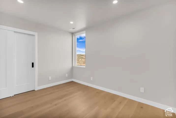 Recessed lighting, wood-finish flooring, and a large window