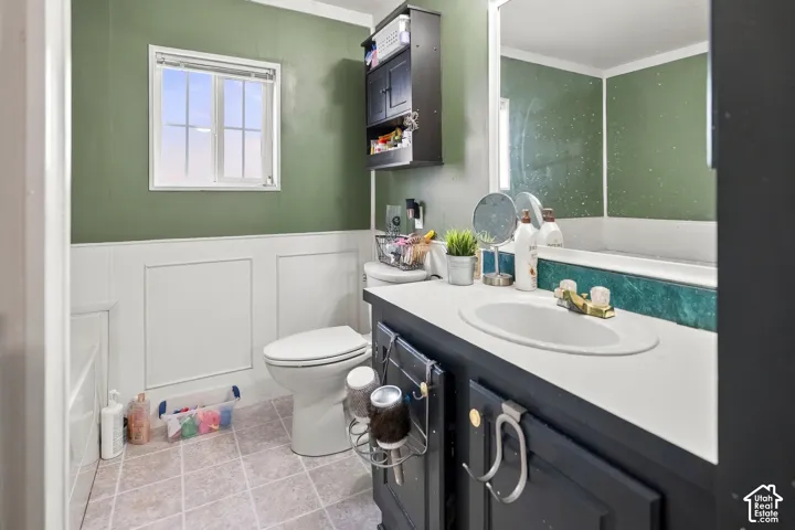 Built-in vanity with integrated sink, paneling, and a mounted mirror