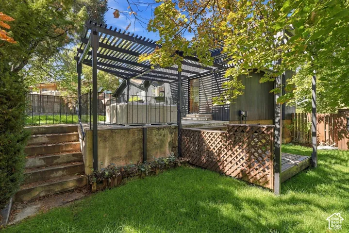 Black metal pergola structure over an elevated patio