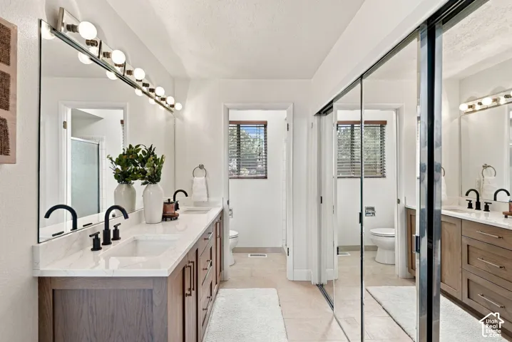 Dual wood-finish vanities with undermount sinks and matte black hardware