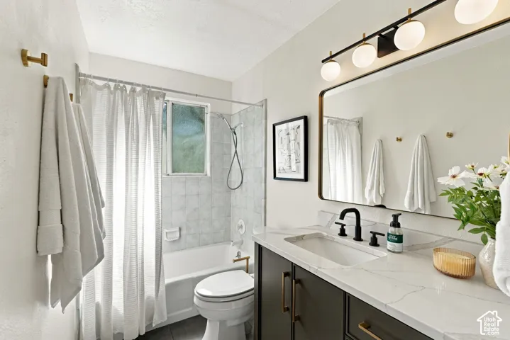 Bathroom featuring a single vanity with a white countertop and dark cabinetry, matte black faucet, and rectangular framed mirror