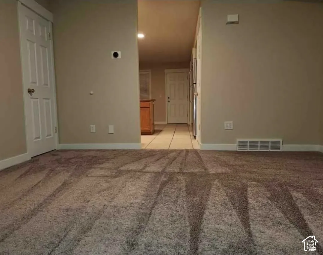 Carpeted flooring, neutral wall tones, white trim, and a white six-panel door