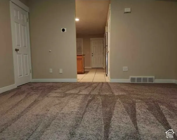 Carpeted flooring, neutral wall tones, white trim, and a white six-panel door