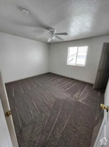Recessed window with blinds, ceiling fan with integrated lighting, and neutral tone carpet flooring