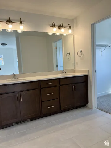 Dual vanity with dark wood-finish cabinetry, integrated sinks, and polished chrome fixtures