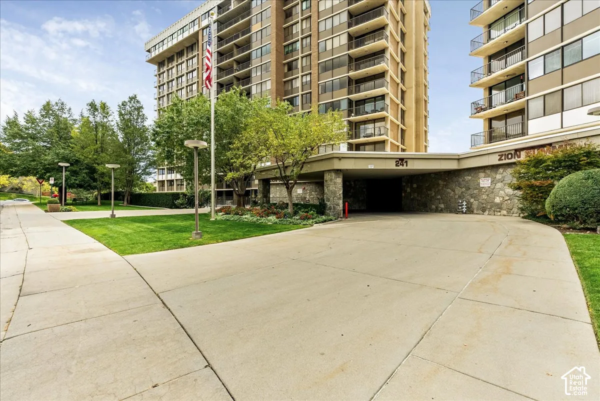 Entry drive with an overhead canopy, stone facade, and integrated lighting