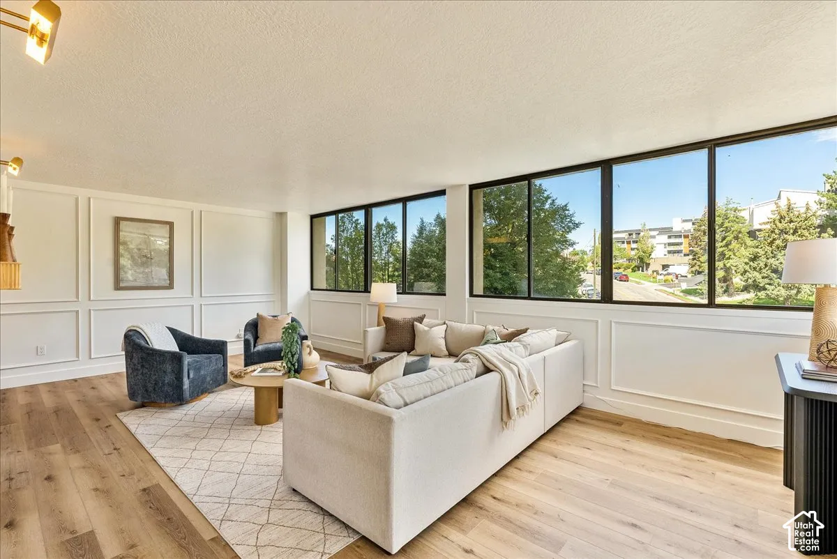 Wall paneling, wood-finish flooring, and expansive windows with black frames