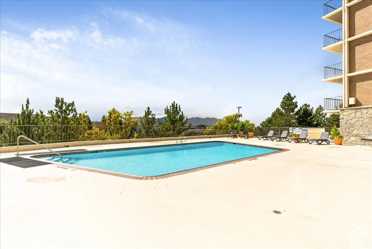 Rectangular outdoor pool with integrated steps, surrounded by a light-colored concrete deck