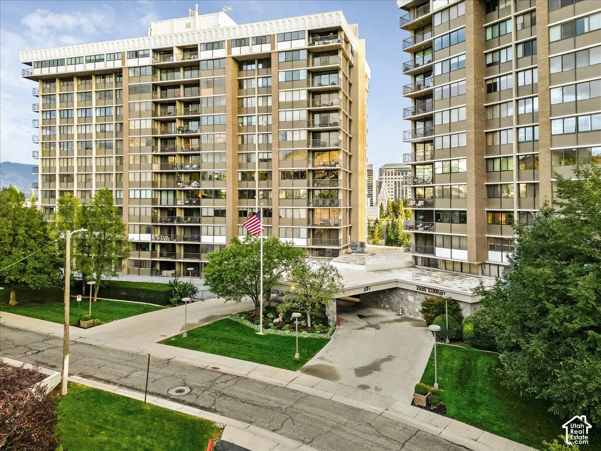 Multi-story residential buildings with expansive windows, individual balconies, and a covered entry drive