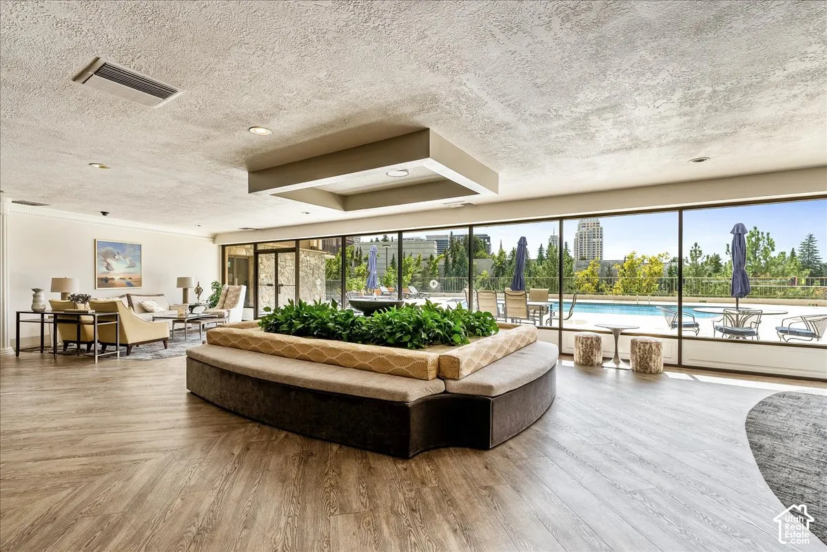 Expansive gathering area featuring wood-finish flooring, recessed lighting, and a built-in planter