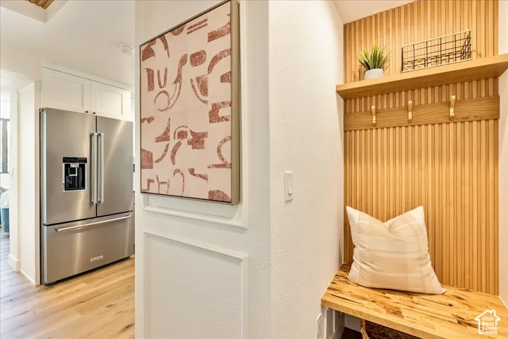 Wood-finish flooring, built-in wooden bench, integrated shelving, and vertical slat wood paneling