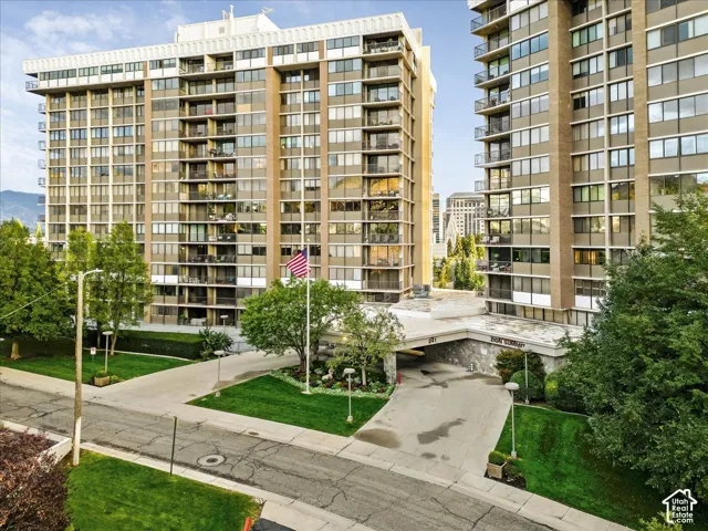 Multi-story residential buildings with expansive windows, individual balconies, and a covered entry drive
