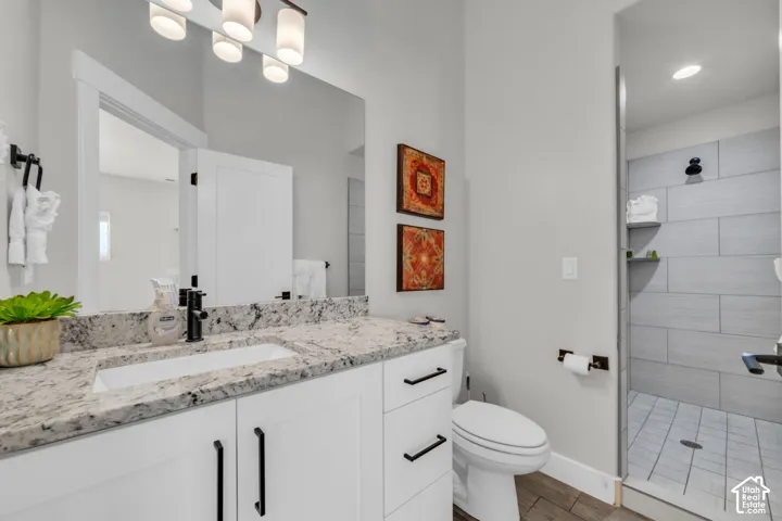 White vanity with black hardware, granite countertop, rectangular undermount sink, and matte black faucet