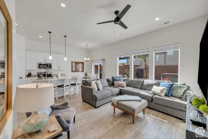 Open-concept living space featuring wood-finish flooring, recessed lighting, and a ceiling fan