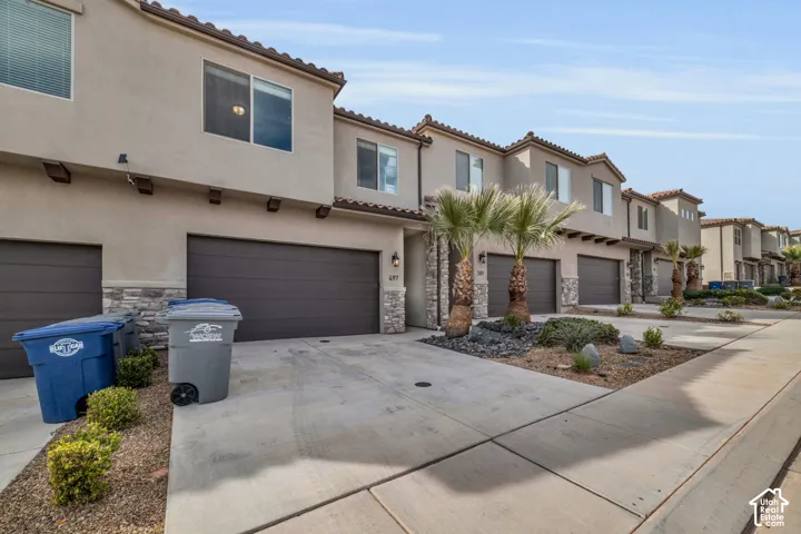 Stucco exterior with stone accents and arched tile roofing