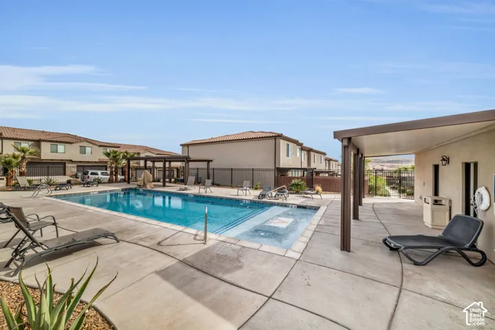 Community pool with integrated spa and surrounding concrete patio