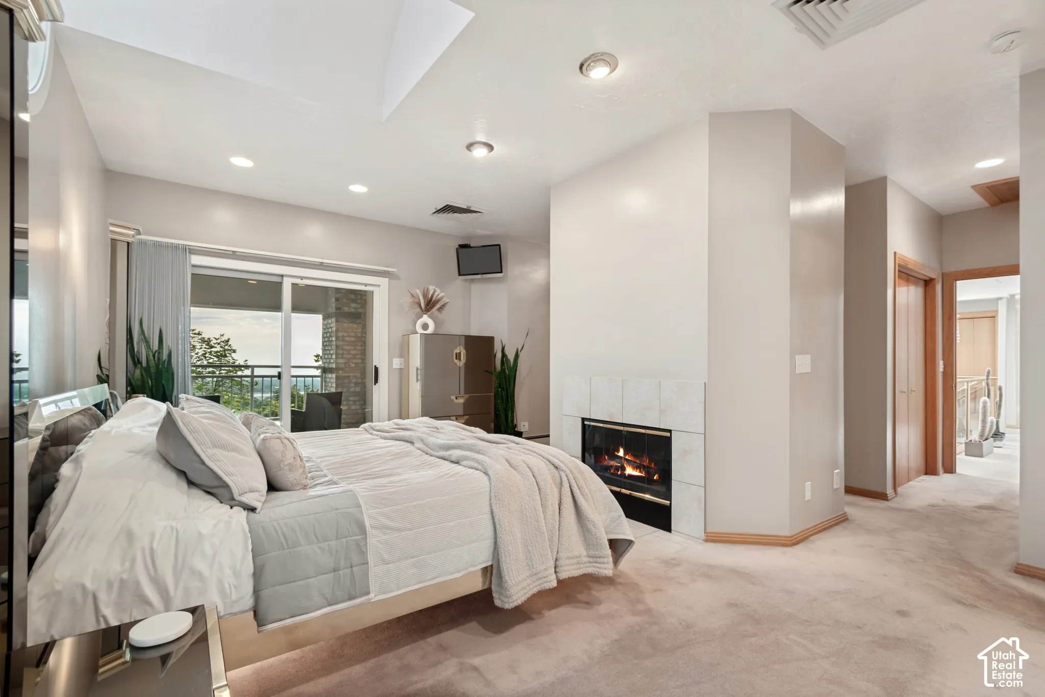 Primary bedroom with private balcony, fireplace and valley views out of windows
