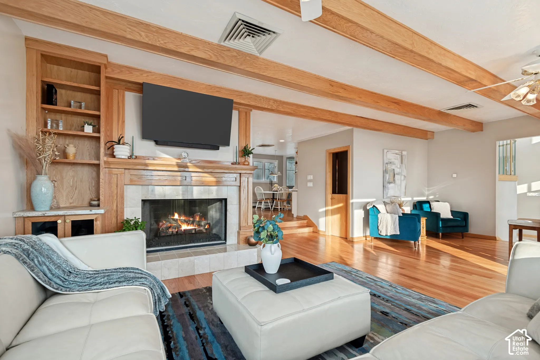 Living room with wood beams, hardwood floors & fireplace.