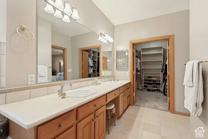 Dual vanity with integrated sinks, wood-finish cabinetry, and a large wall-mounted mirror