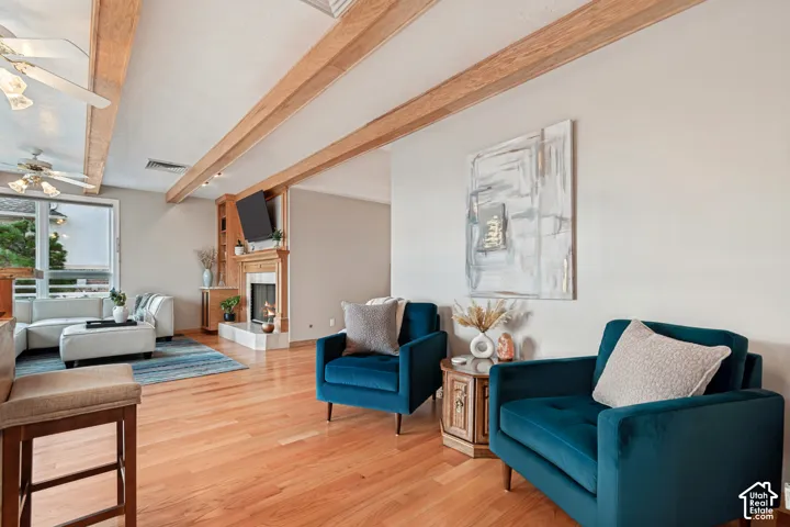 Living room with wood beams, hardwood floors & fireplace. Valley views out windows.