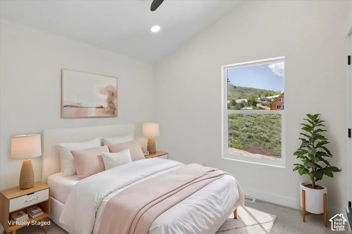 Upstairs Bedroom 1. Vaulted ceiling, recessed lighting, double-hung window, and neutral wall tones
