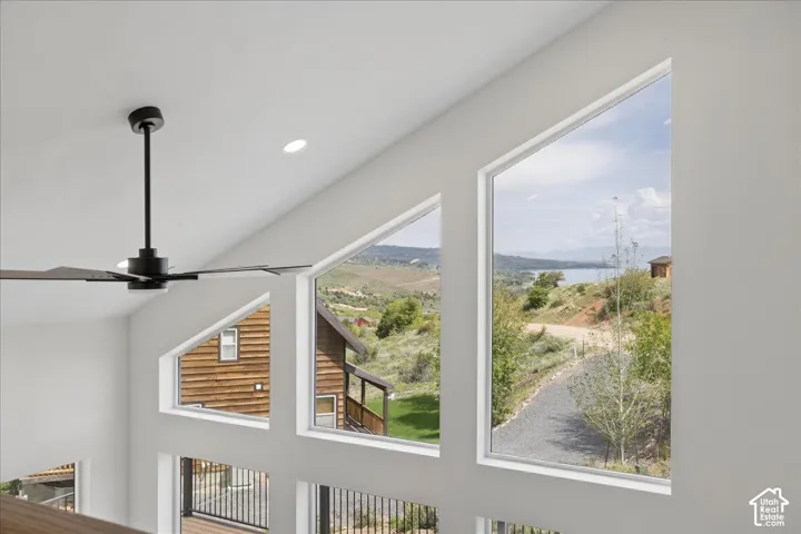 Vaulted ceiling with recessed lighting and a black ceiling fan