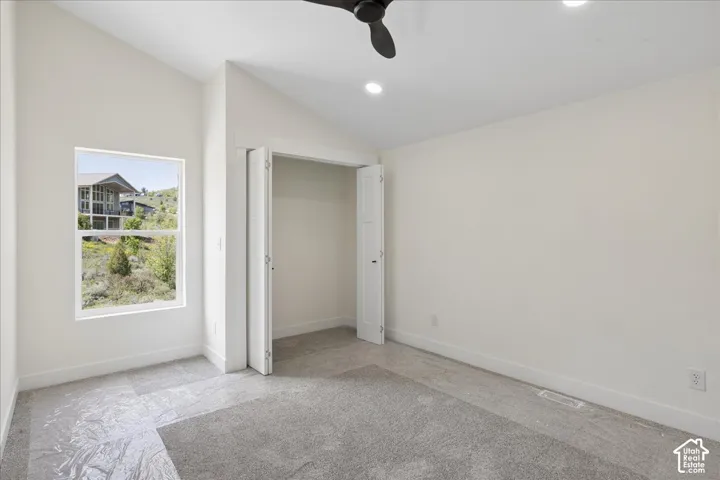 Upstairs Bedroom 2. Vaulted ceiling with recessed lighting, single window, and a ceiling fan