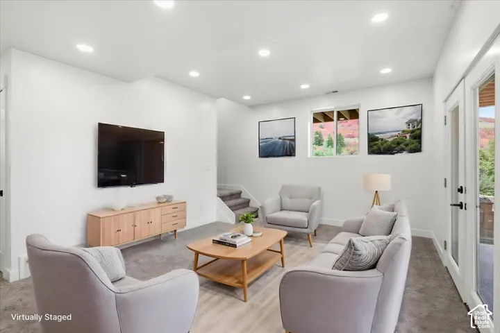 Recessed lighting, wood-finish flooring, white walls, and a glass-paneled door
