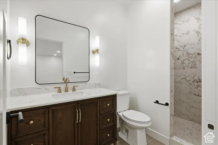 Master bathroom. Dark wood-finish vanity with gold-tone hardware, white countertop, and integrated sink