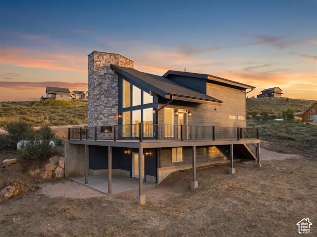 Modern exterior featuring varied siding and a prominent stone-clad chimney