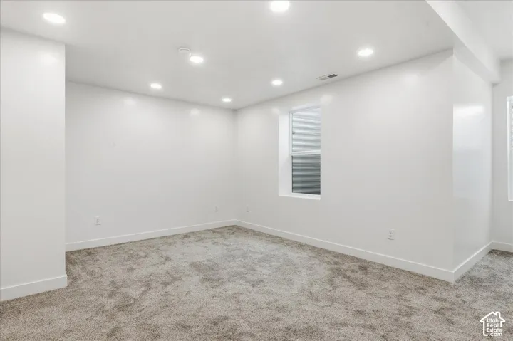 Primary Bedroom. Recessed lighting, light-toned carpeting, and white painted walls