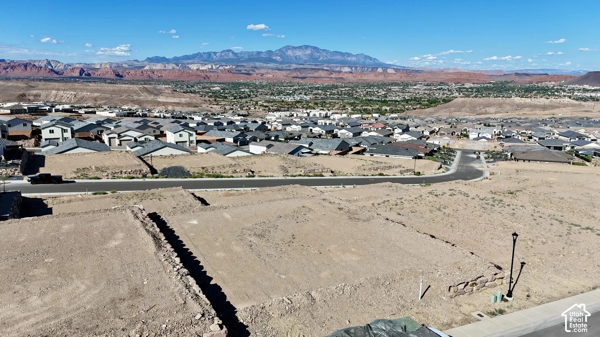 Expansive desert landscape with distant mountains and a residential community
