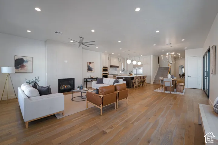 Open-concept living space featuring hardwood flooring throughout, recessed ceiling lighting, and a ceiling fan