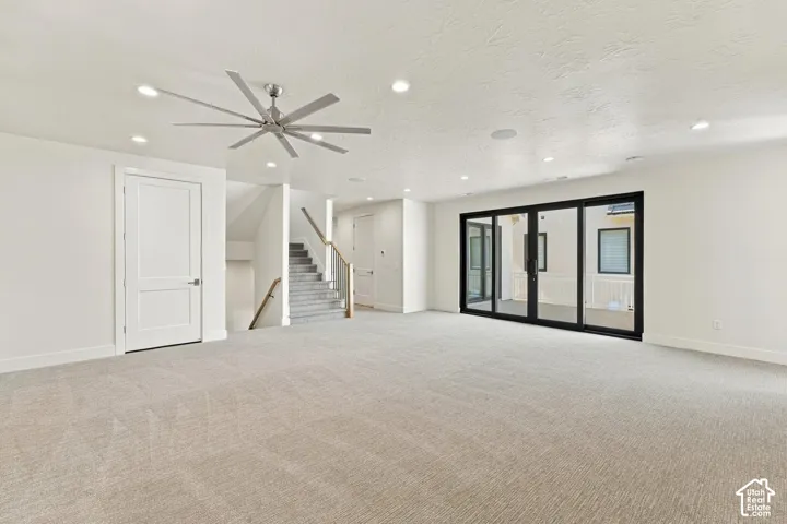 Spacious room featuring light-colored carpeting, recessed lighting, and a contemporary ceiling fan