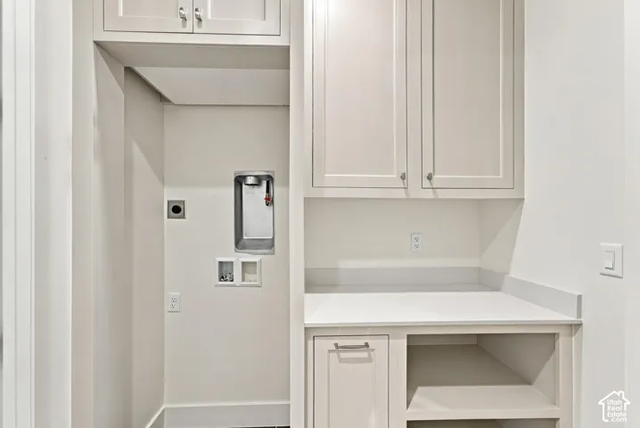 Built-in cabinetry with shaker-style doors, durable countertop, open shelving, and a dedicated appliance recess