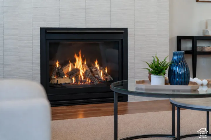 Built-in fireplace with a black surround, featuring a textured tile wall and wood-finish flooring
