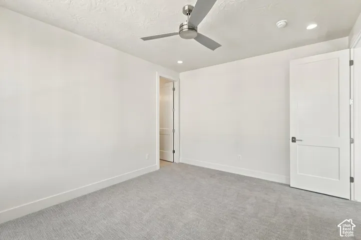 Neutral-toned wall-to-wall carpeting complements the light wall color