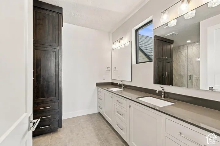 Dual vanity with white cabinetry and dark countertops