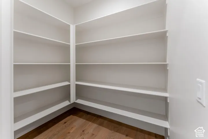 Built-in white shelving, recessed lighting, and wood-finish flooring