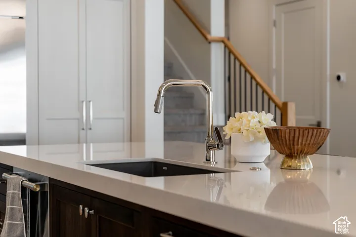Kitchen island featuring a built-in sink, polished chrome faucet, and integrated cabinetry