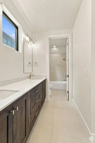 Double vanity with dark wood-finish cabinetry, white countertop, and dual undermount sinks