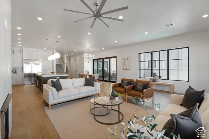 Open-concept living area with wood-finish flooring, recessed lighting, and a modern ceiling fan