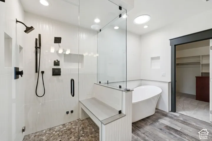 Glass-enclosed shower with pebble-tile flooring and an integrated bench