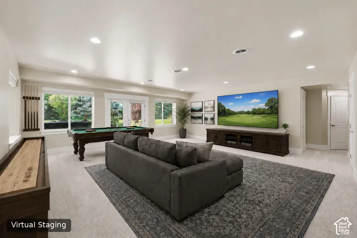 Recessed lighting, light-colored walls, carpeted flooring, built-in media console, and multiple windows