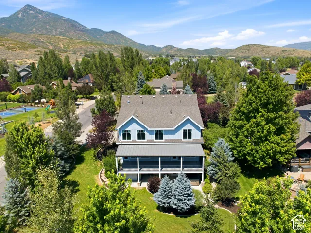 Two-story residence with a gray shingle roof, light blue siding, and white trim