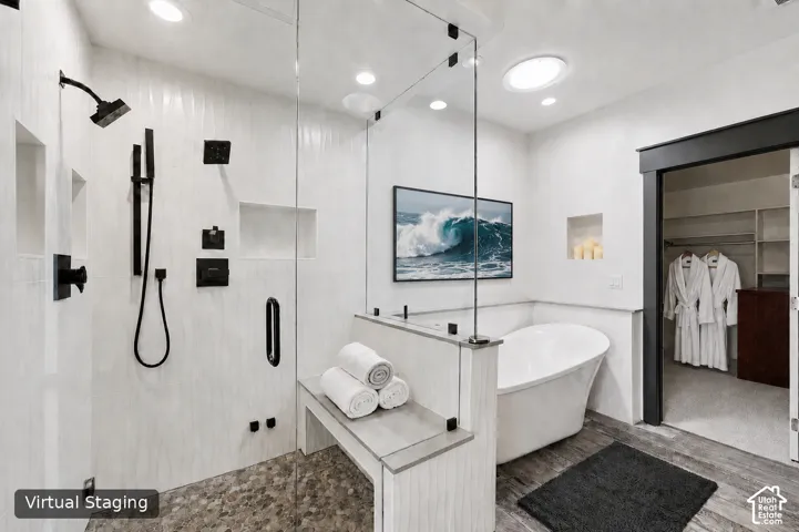 Primary Bathroom. Glass-enclosed shower with matte black fixtures, freestanding soaking tub, recessed lighting, built-in shower bench, and a skylight