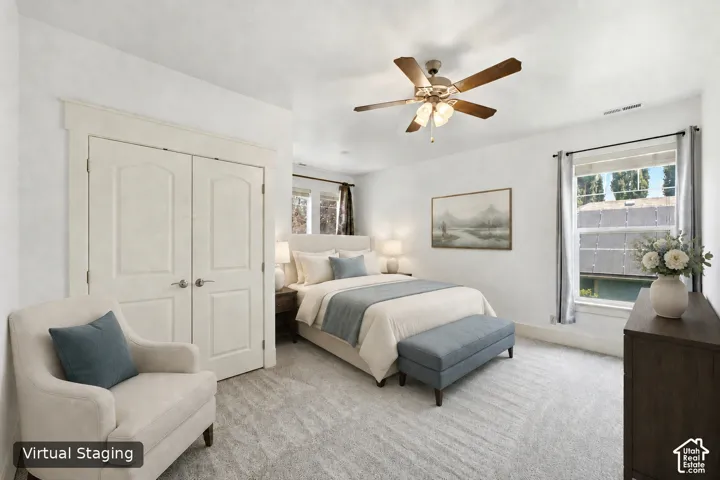White walls with a ceiling fan, light-colored carpeting, and a double-door closet with arch paneling